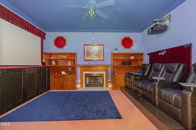 cinema featuring ceiling fan, crown molding, and carpet flooring