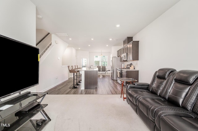 living room featuring dark hardwood / wood-style floors, a notable chandelier, and sink