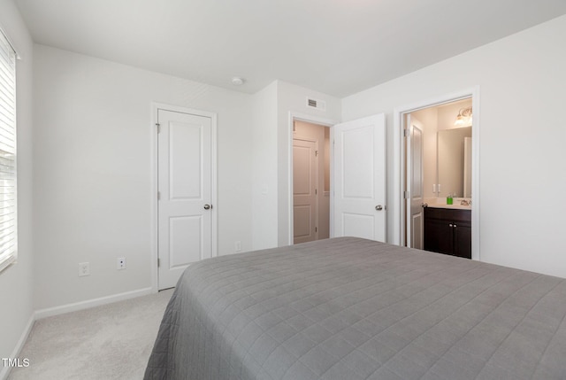 carpeted bedroom with connected bathroom and multiple windows