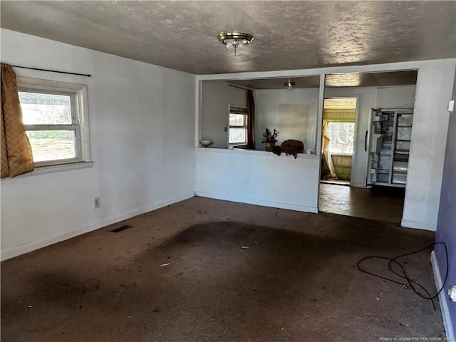 spare room featuring a textured ceiling and a healthy amount of sunlight