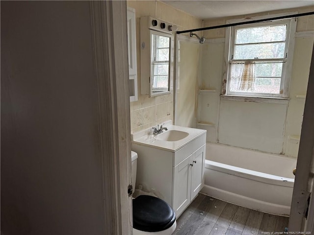 full bathroom with tasteful backsplash, shower / bathtub combination, vanity, hardwood / wood-style flooring, and toilet