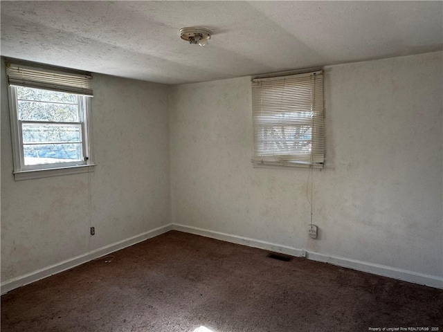 carpeted spare room featuring a textured ceiling