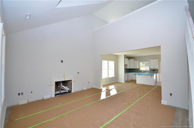 unfurnished living room with high vaulted ceiling