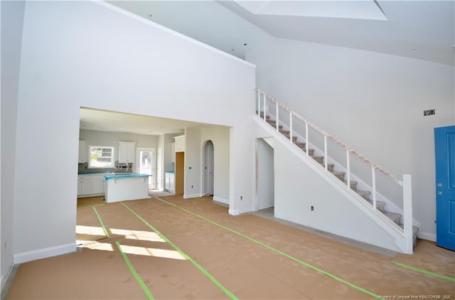 unfurnished living room with high vaulted ceiling