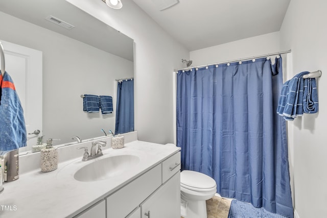 bathroom featuring tile patterned floors, vanity, toilet, and walk in shower