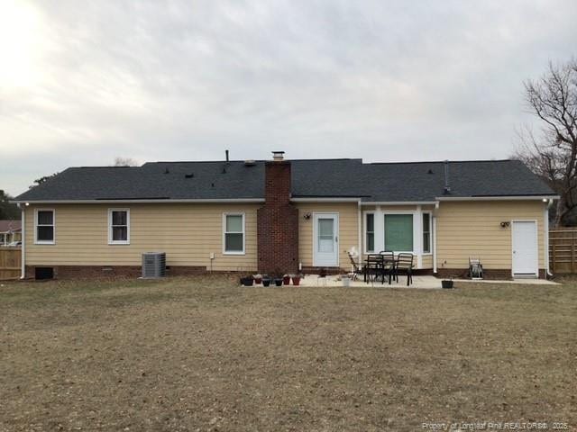 back of property featuring a lawn, a patio, and central AC unit