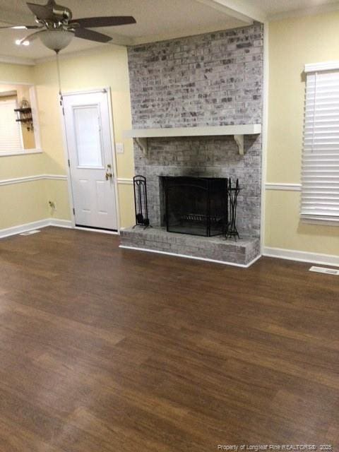 unfurnished living room featuring a fireplace, ceiling fan, and dark wood-type flooring