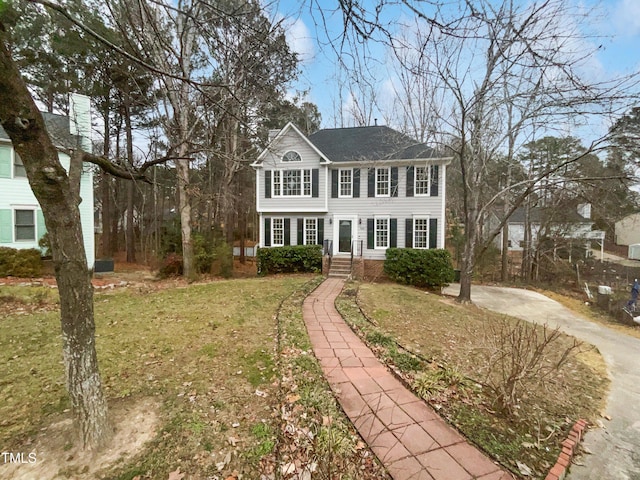 colonial home featuring a front yard