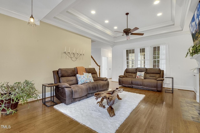 living room featuring a tray ceiling, ceiling fan, and hardwood / wood-style floors