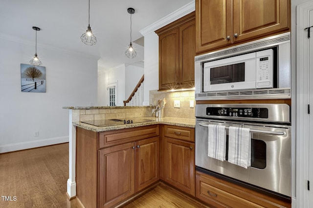 kitchen featuring kitchen peninsula, stainless steel oven, white microwave, and ornamental molding