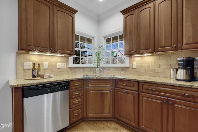 kitchen featuring dishwasher, backsplash, sink, light hardwood / wood-style flooring, and light stone countertops