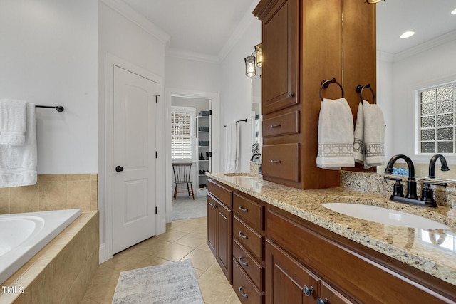 bathroom featuring tile patterned flooring, vanity, tiled bath, and crown molding