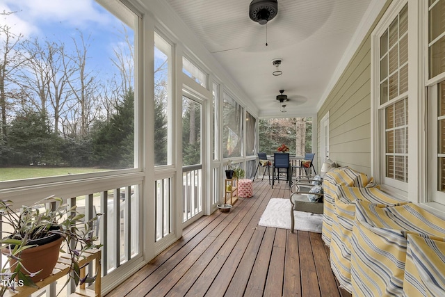 sunroom / solarium featuring ceiling fan and a healthy amount of sunlight