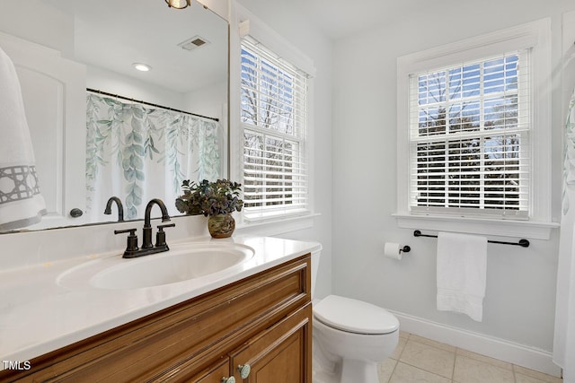 bathroom with tile patterned floors, vanity, toilet, and walk in shower