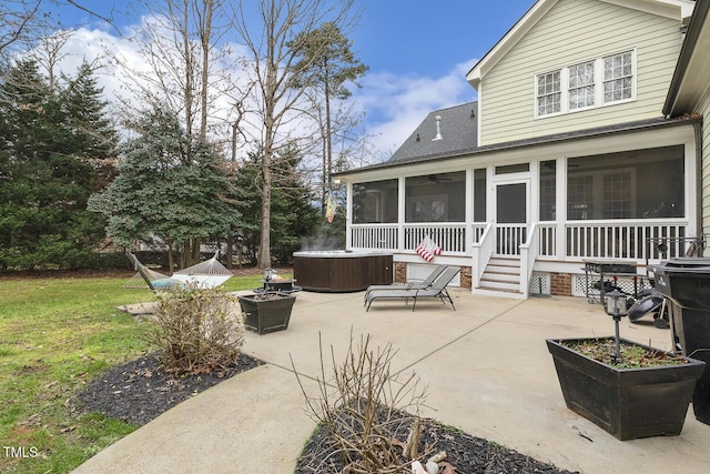 view of patio / terrace featuring a sunroom and a hot tub