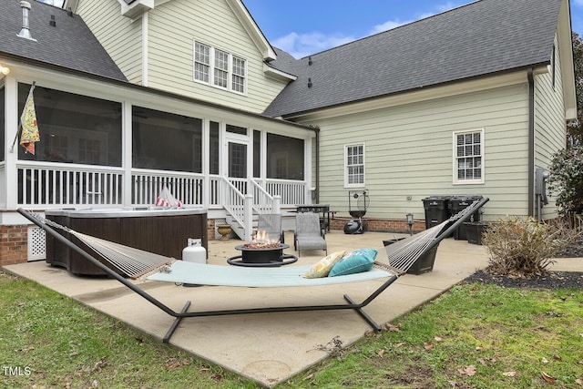 back of house featuring a patio area, a sunroom, and a fire pit