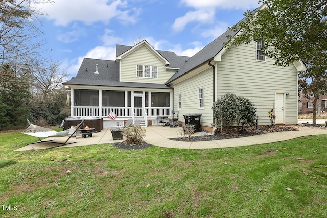 back of house featuring a lawn, a patio area, and a sunroom