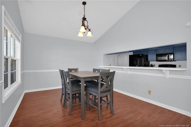 dining area with dark hardwood / wood-style flooring, high vaulted ceiling, and a notable chandelier