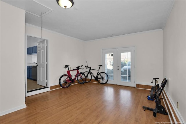 exercise room featuring hardwood / wood-style floors, french doors, and crown molding