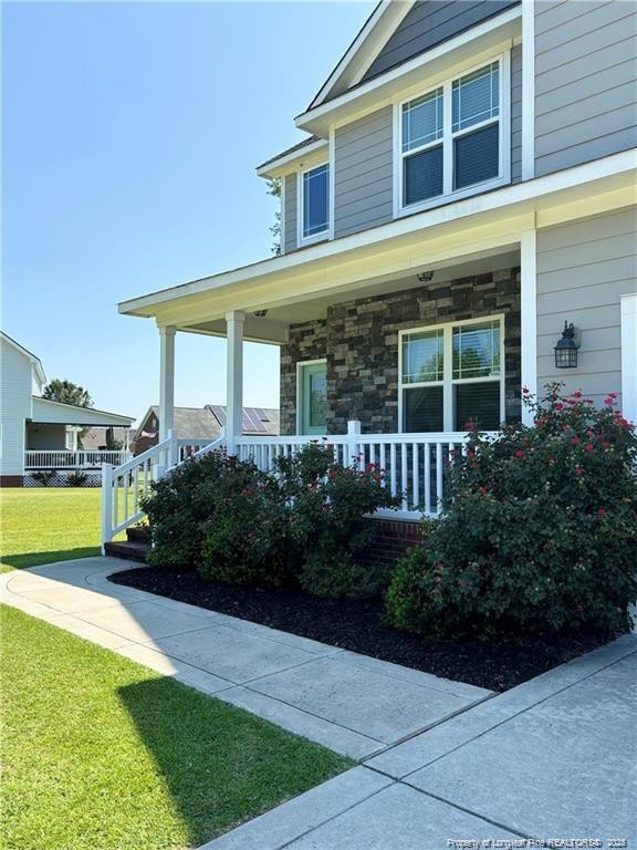 view of front of home featuring covered porch and a front lawn