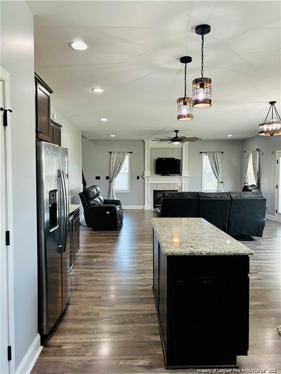 kitchen with stainless steel fridge with ice dispenser, a kitchen island, pendant lighting, and ceiling fan