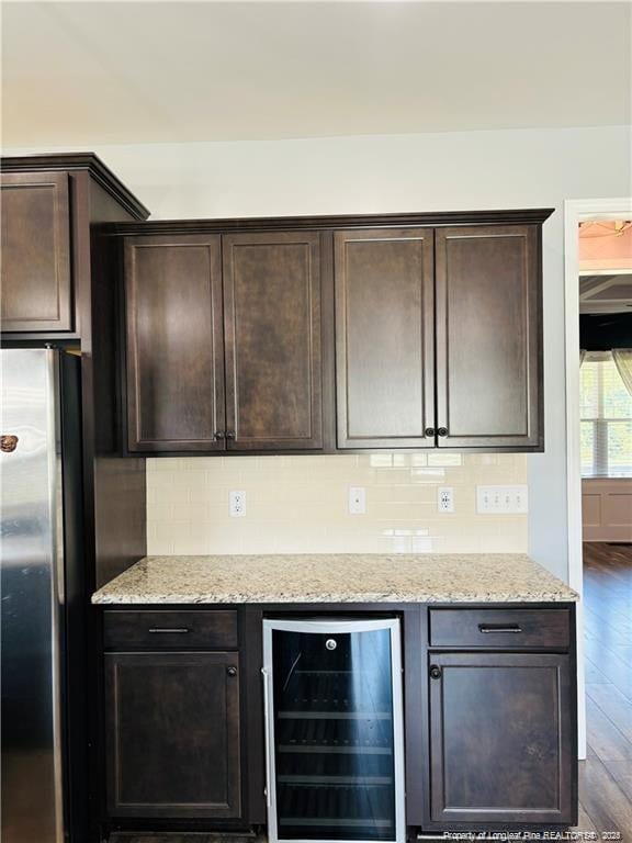 kitchen with stainless steel fridge, dark brown cabinets, beverage cooler, and dark hardwood / wood-style floors