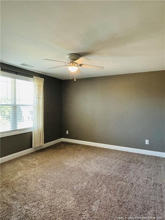 carpeted spare room featuring ceiling fan