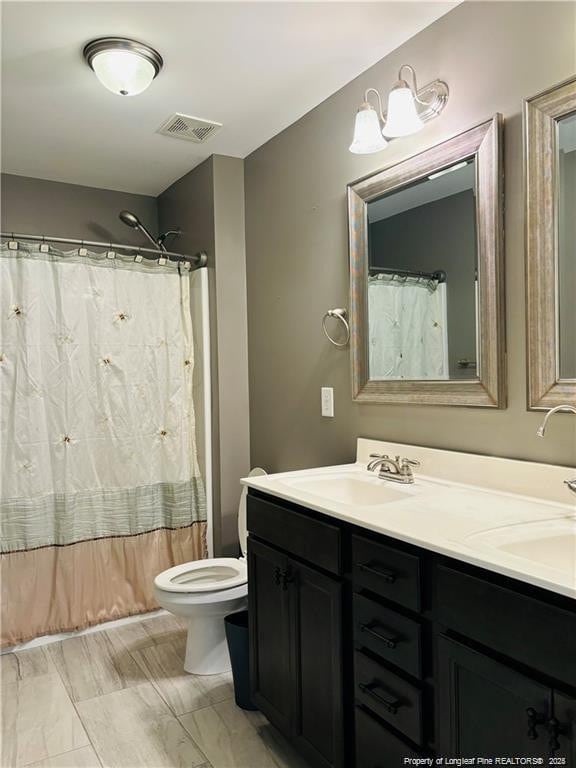 bathroom with a shower with curtain, vanity, and toilet