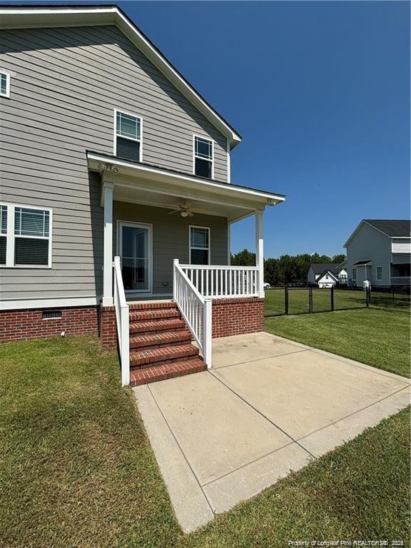 view of front facade with a porch, a front lawn, and ceiling fan