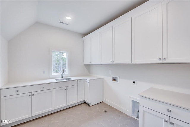 clothes washing area with sink, cabinets, hookup for an electric dryer, hookup for a washing machine, and light tile patterned flooring