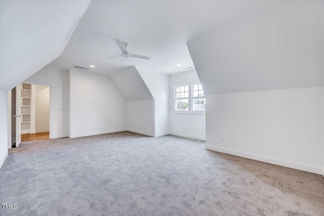 additional living space featuring ceiling fan, light carpet, and vaulted ceiling