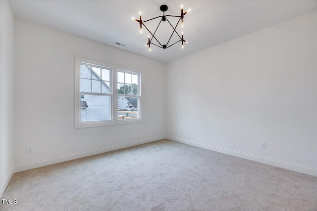 unfurnished room with a notable chandelier and carpet floors