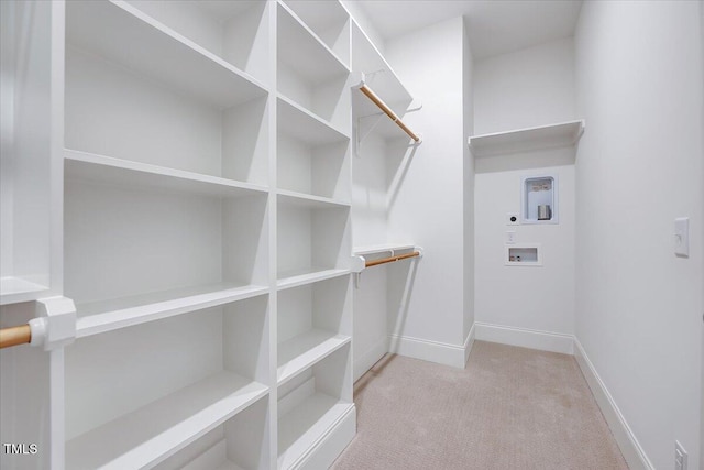 walk in closet featuring light carpet