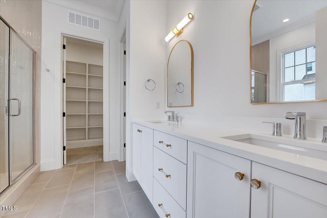 bathroom featuring vanity, tile patterned floors, a shower with shower door, and crown molding