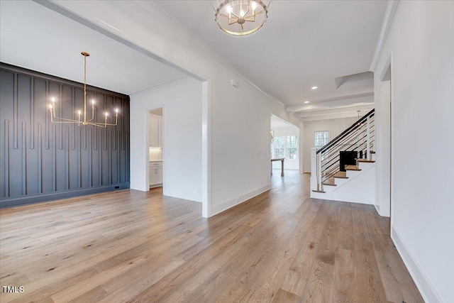 foyer entrance featuring ornamental molding, light hardwood / wood-style flooring, and a chandelier