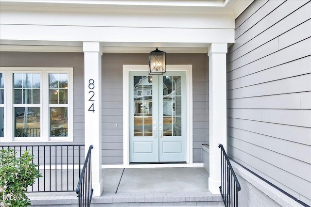 property entrance with covered porch and french doors