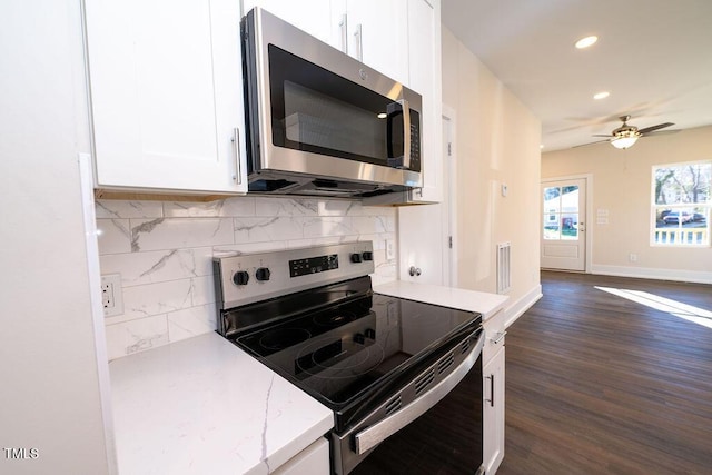 kitchen with white cabinets, decorative backsplash, dark hardwood / wood-style floors, ceiling fan, and appliances with stainless steel finishes