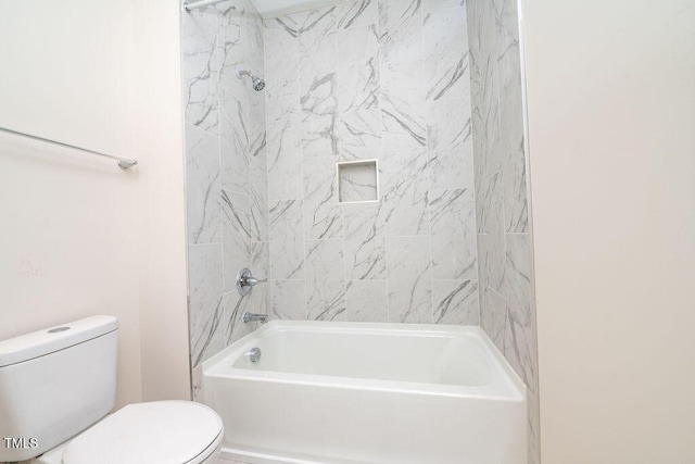 bathroom featuring tiled shower / bath and toilet