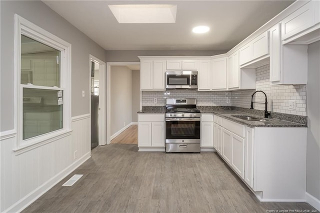 5193 Southport Dr, Fayetteville, NC 28311 - kitchen with stainless steel appliances, white cabinetry, dark stone countertops, and sink