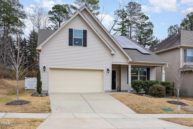 view of front of home with a garage, solar panels, and a porch