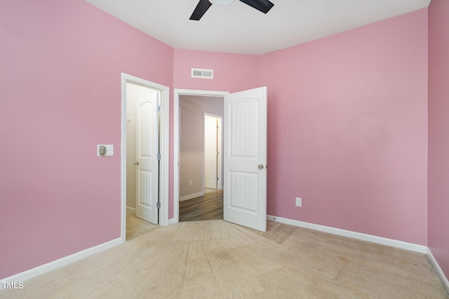 unfurnished bedroom featuring light colored carpet and ceiling fan