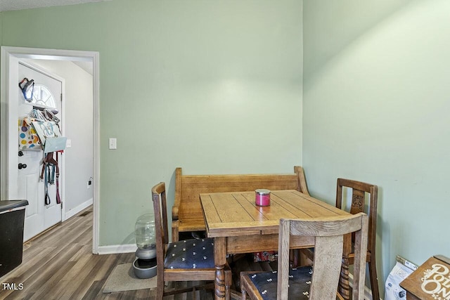 dining area featuring hardwood / wood-style floors and vaulted ceiling