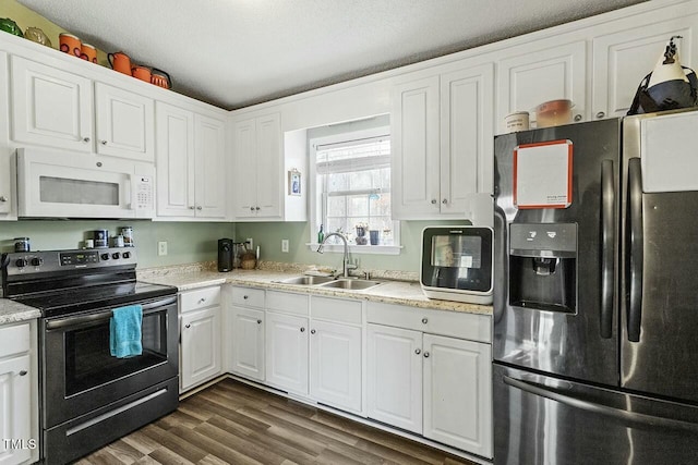 kitchen featuring stainless steel appliances, dark wood-type flooring, a textured ceiling, white cabinets, and sink