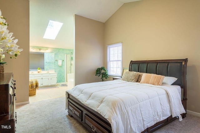 carpeted bedroom featuring ensuite bath and lofted ceiling with skylight