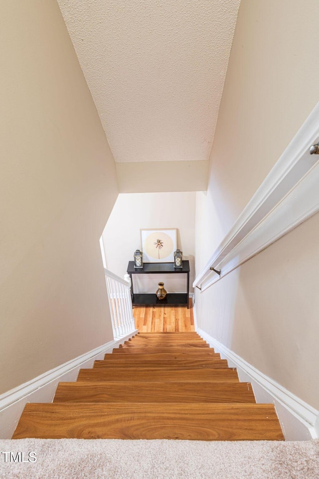 stairway with a textured ceiling