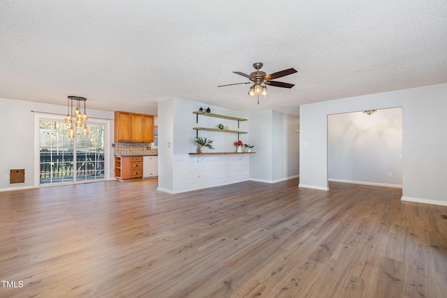 unfurnished living room featuring ceiling fan, light hardwood / wood-style flooring, and a textured ceiling