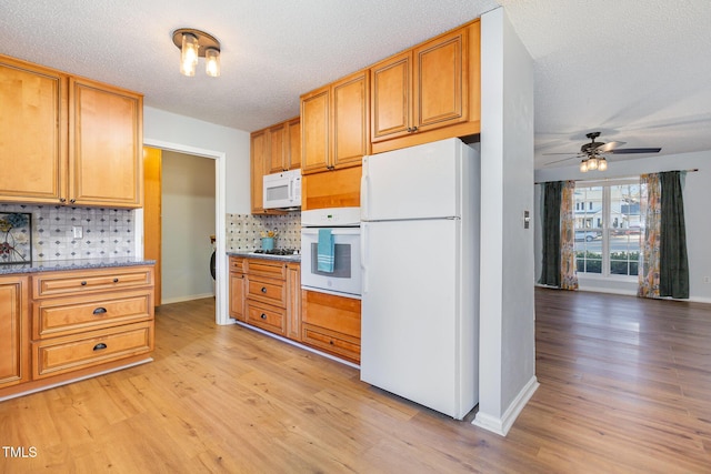 kitchen with decorative backsplash, white appliances, a textured ceiling, and light hardwood / wood-style flooring