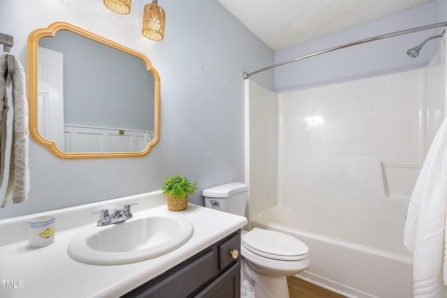 full bathroom featuring a textured ceiling, toilet, shower / washtub combination, vanity, and hardwood / wood-style flooring