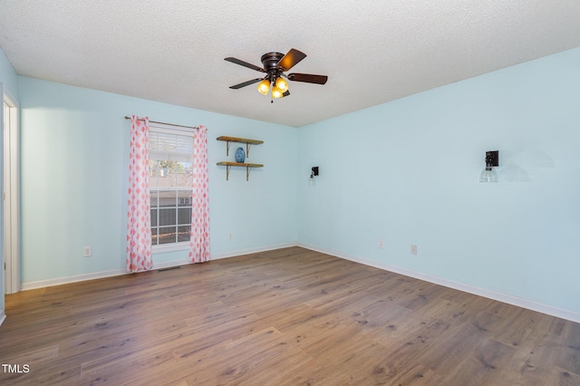 unfurnished room featuring ceiling fan, hardwood / wood-style floors, and a textured ceiling