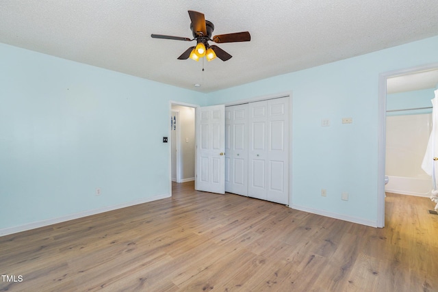 unfurnished bedroom with light wood-type flooring, ensuite bathroom, a textured ceiling, ceiling fan, and a closet